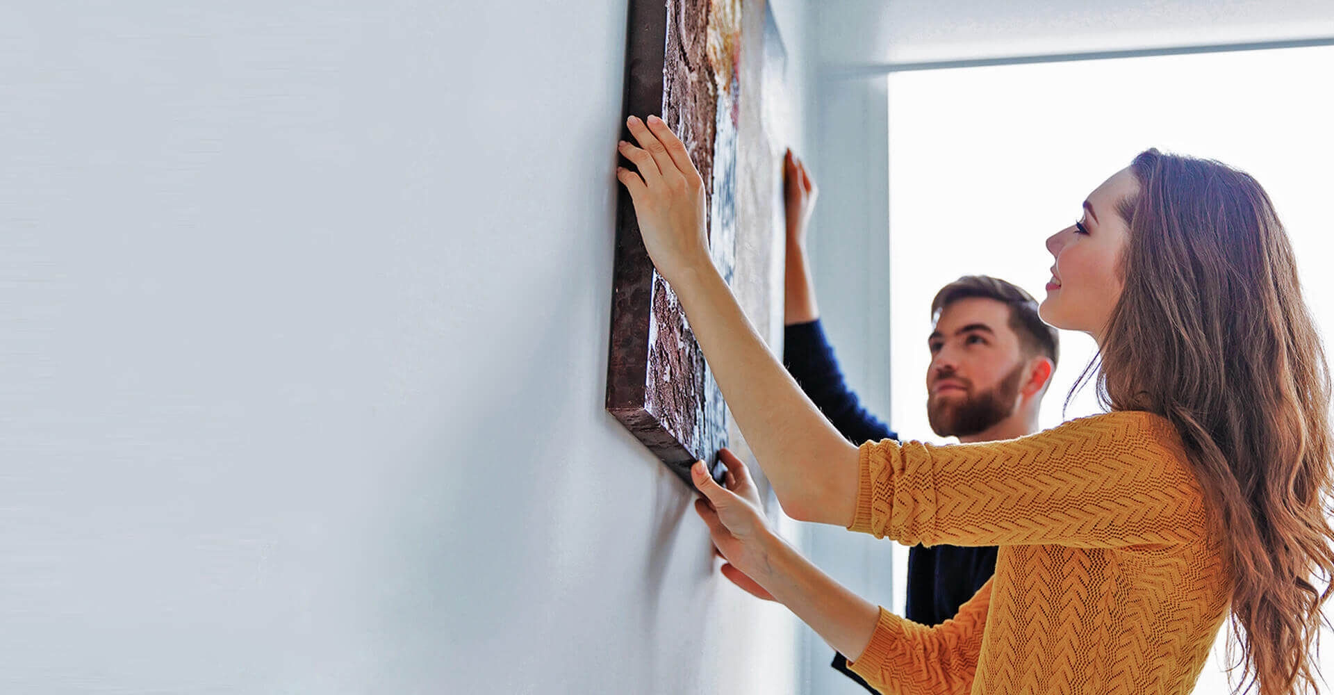 Couple hanging up pictures