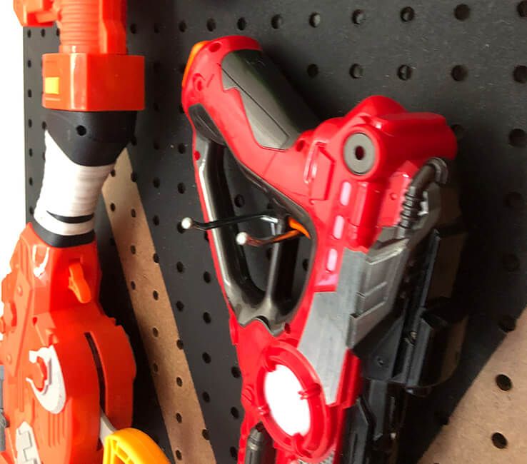 Toy Laser Tag gun hanging from pegboard